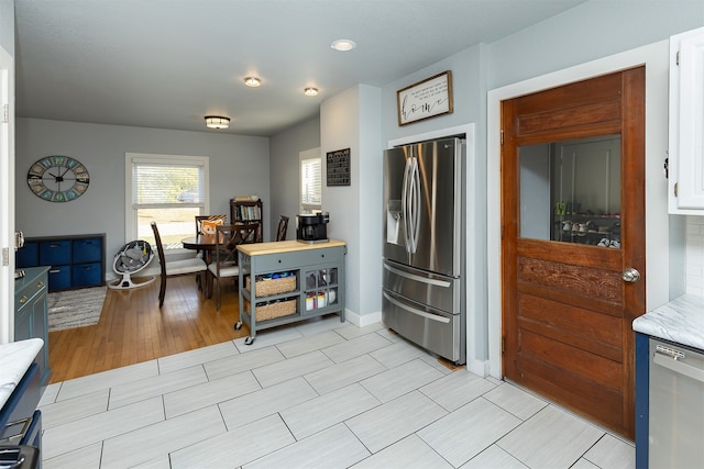 kitchen featuring light hardwood / wood-style flooring, stainless steel appliances, and white cabinetry