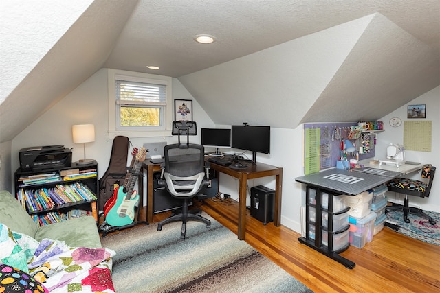 office space featuring a textured ceiling, vaulted ceiling, and wood-type flooring