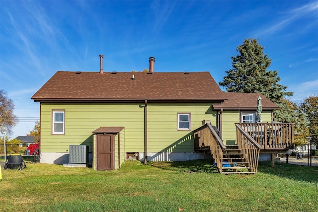 rear view of property with a deck and a yard