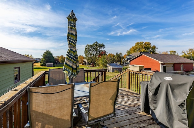 wooden deck featuring area for grilling and a lawn