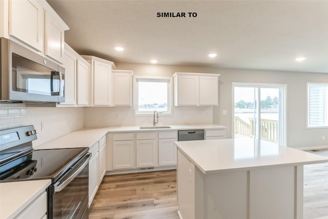 kitchen featuring light countertops, appliances with stainless steel finishes, a sink, and white cabinets