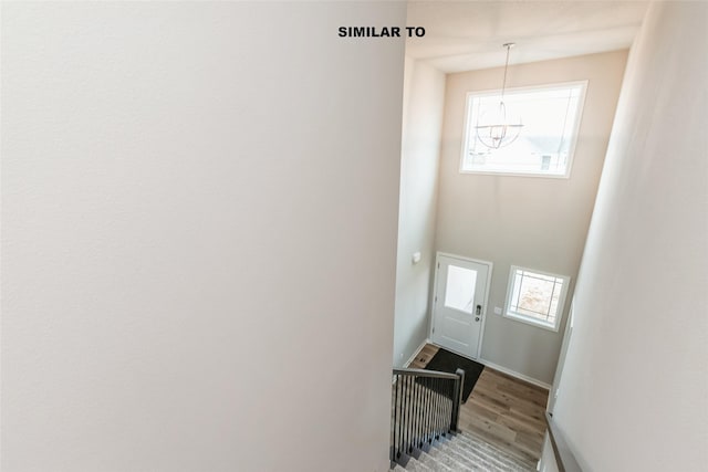 staircase featuring a wealth of natural light, baseboards, and wood finished floors