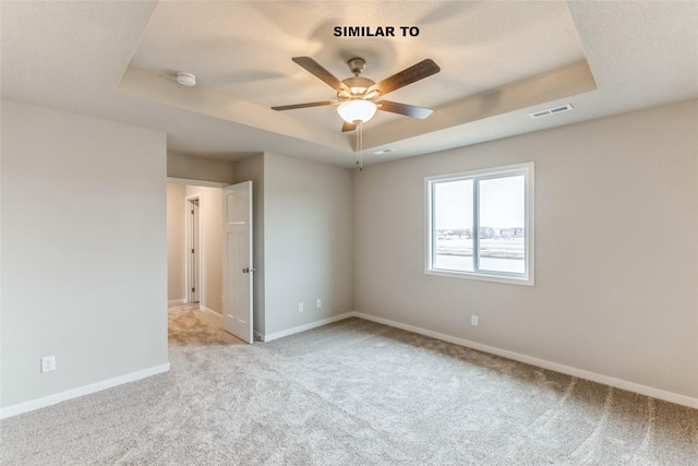 unfurnished bedroom with visible vents, baseboards, a raised ceiling, light colored carpet, and ceiling fan