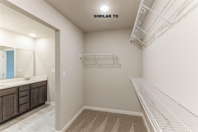 spacious closet with light carpet and a sink