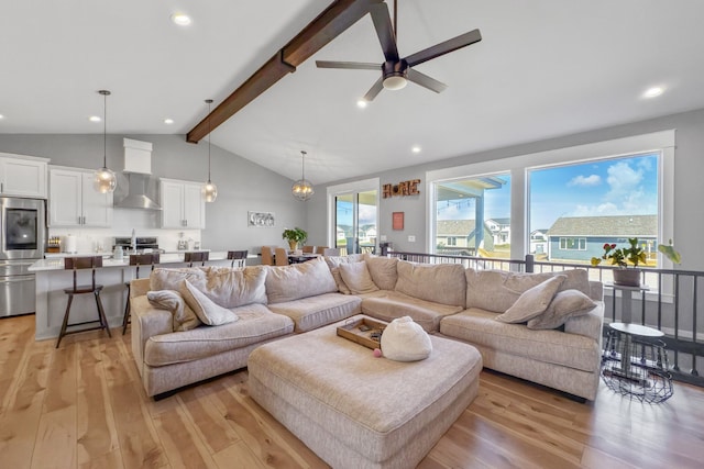 living room with light hardwood / wood-style floors, lofted ceiling with beams, and ceiling fan