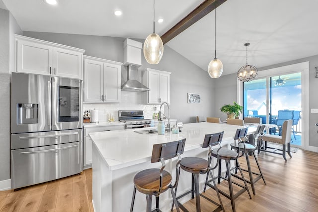 kitchen featuring a kitchen island with sink, stainless steel appliances, sink, lofted ceiling with beams, and white cabinets