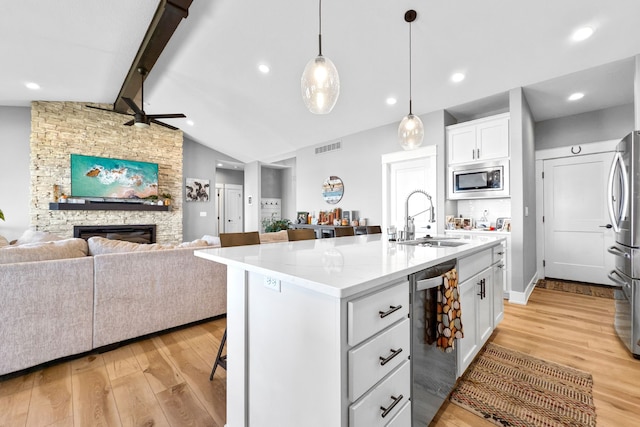 kitchen featuring white cabinets, a kitchen island with sink, light hardwood / wood-style floors, lofted ceiling with beams, and sink