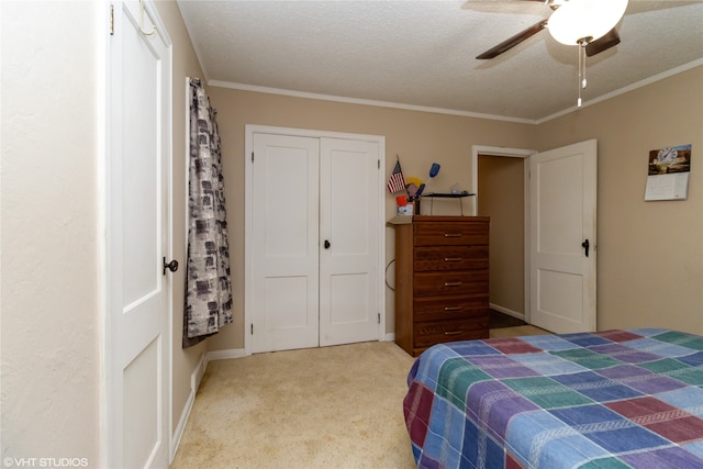 carpeted bedroom featuring crown molding, a textured ceiling, a closet, and ceiling fan