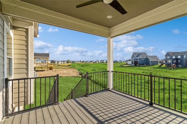 wooden terrace featuring a yard and ceiling fan