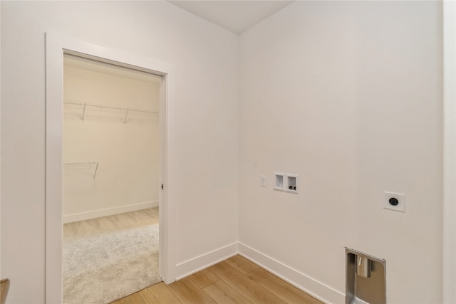 clothes washing area with electric dryer hookup, washer hookup, and light wood-type flooring