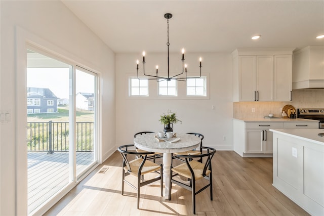 dining room featuring an inviting chandelier, light wood-type flooring, and a healthy amount of sunlight