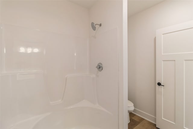 bathroom featuring toilet, shower / bath combination, and hardwood / wood-style floors