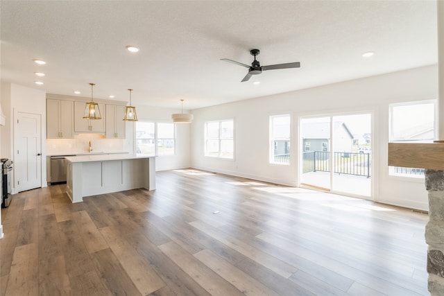 kitchen with light hardwood / wood-style flooring, stainless steel appliances, a center island, pendant lighting, and ceiling fan