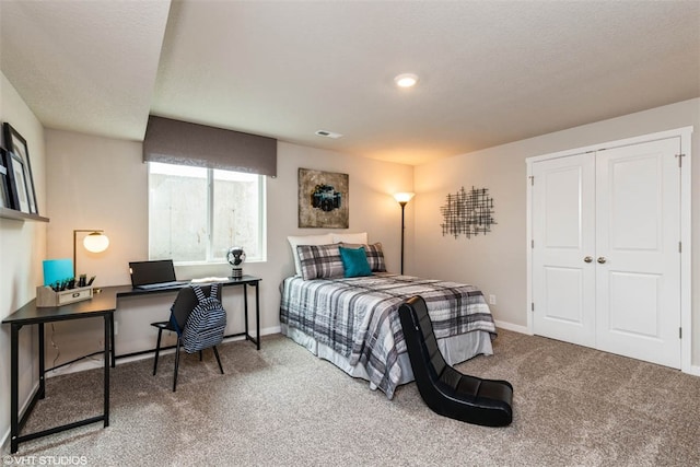 carpeted bedroom with a closet and a textured ceiling