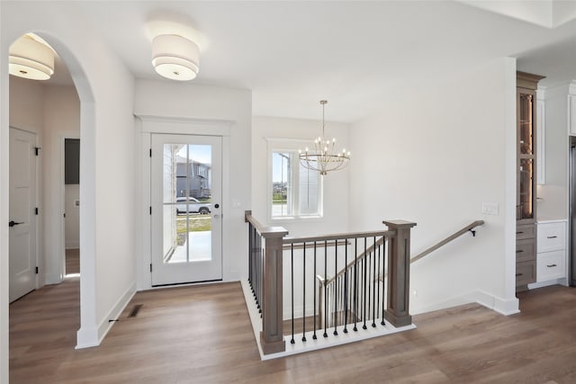 foyer entrance featuring hardwood / wood-style flooring and an inviting chandelier