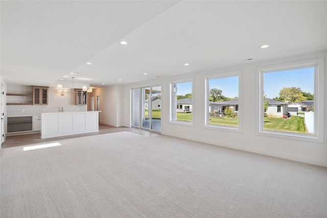 unfurnished living room featuring light colored carpet