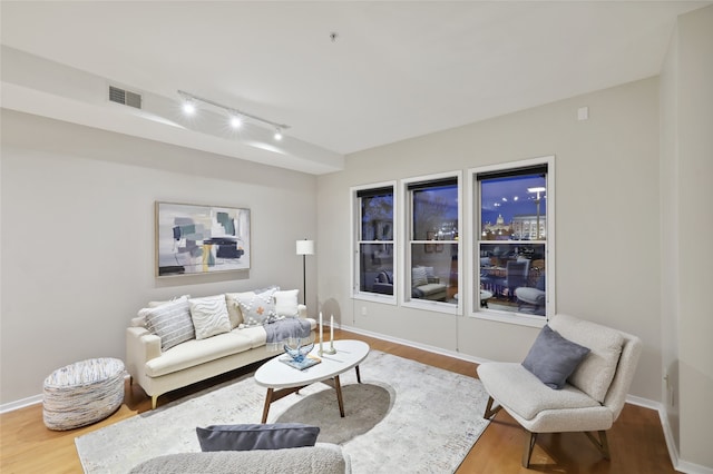 living room with rail lighting and hardwood / wood-style flooring