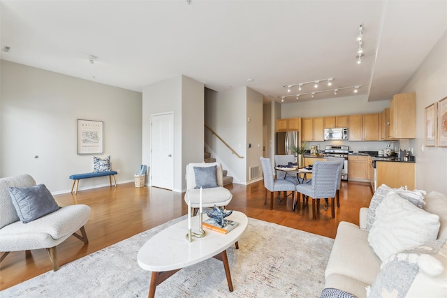 living room featuring track lighting and light hardwood / wood-style flooring