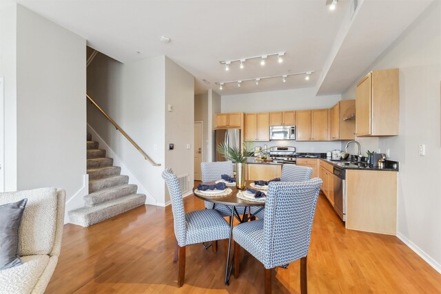 dining room featuring sink and light hardwood / wood-style floors