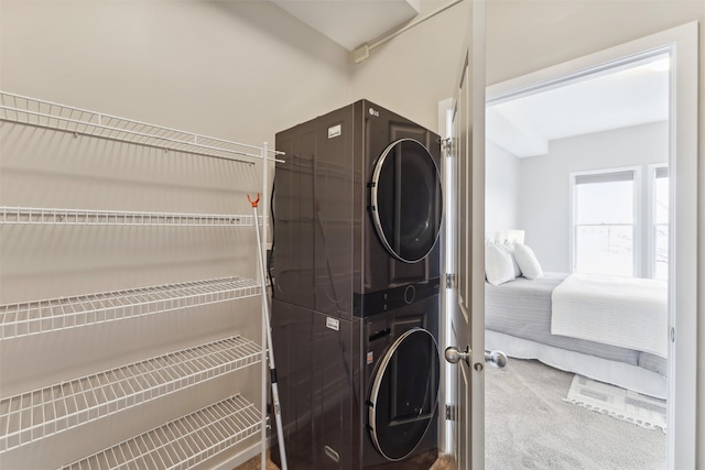 laundry room with stacked washer and dryer and carpet floors