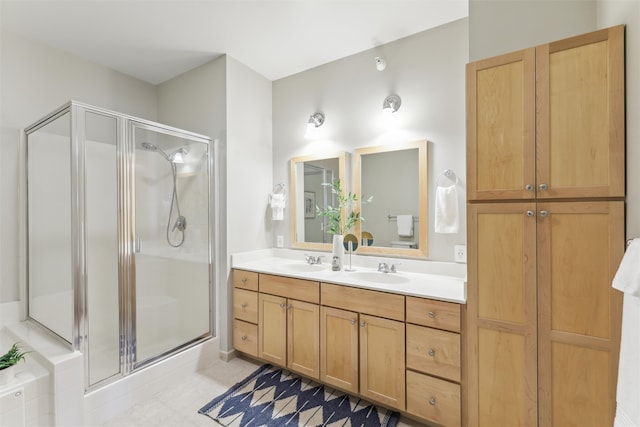 bathroom with an enclosed shower, vanity, and tile patterned flooring