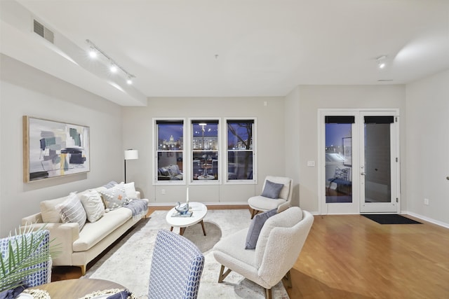 living room with hardwood / wood-style floors, track lighting, and french doors