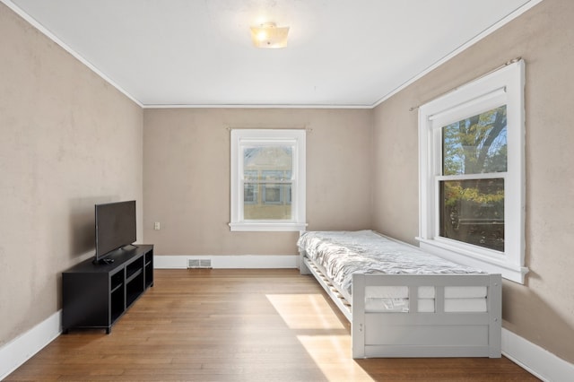 bedroom featuring light hardwood / wood-style flooring and crown molding