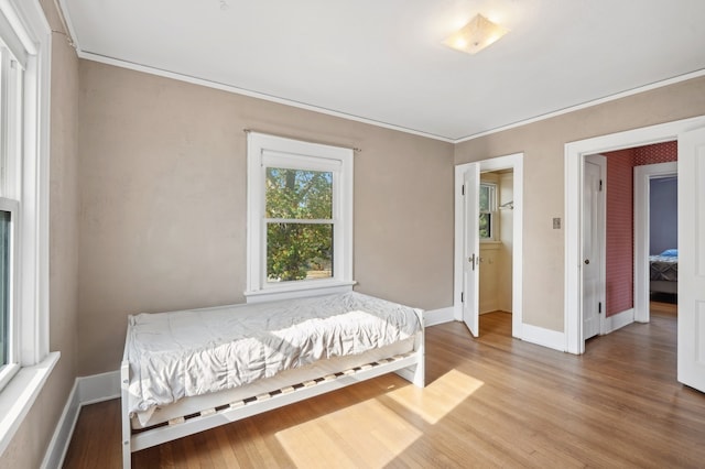 bedroom featuring ornamental molding and hardwood / wood-style floors