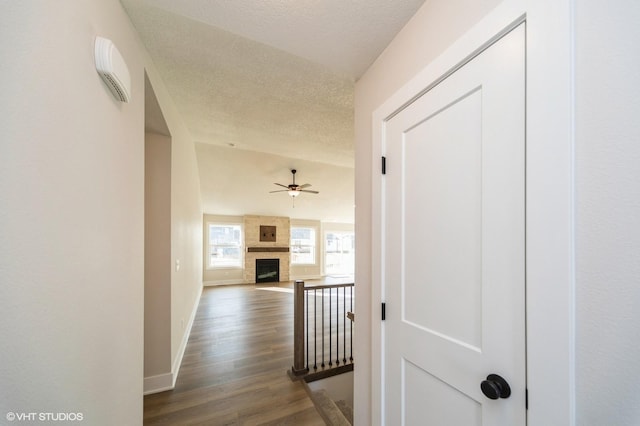 corridor with dark hardwood / wood-style flooring and a textured ceiling