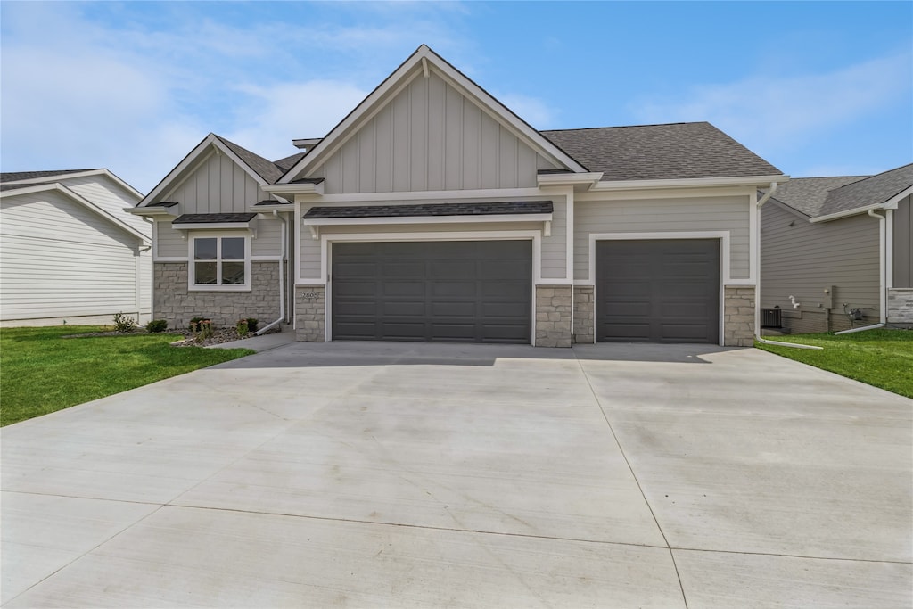 craftsman-style house featuring a front lawn and a garage