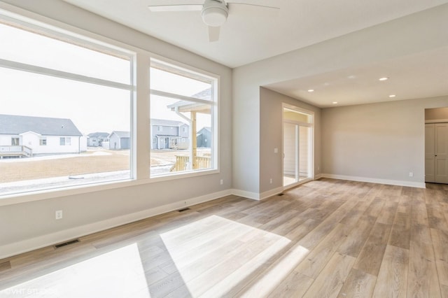 spare room with light wood-style floors, baseboards, and visible vents