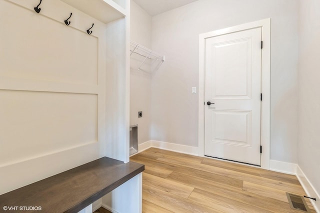 mudroom featuring light wood-type flooring, baseboards, and visible vents