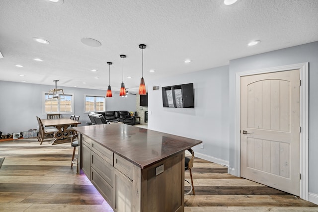 kitchen featuring hanging light fixtures, a breakfast bar area, and hardwood / wood-style floors