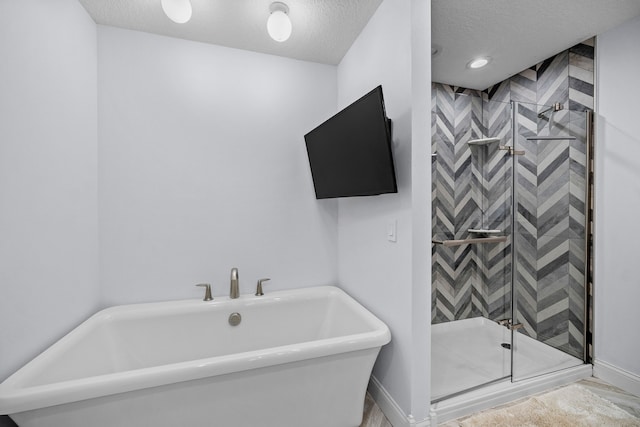 bathroom with shower with separate bathtub and a textured ceiling