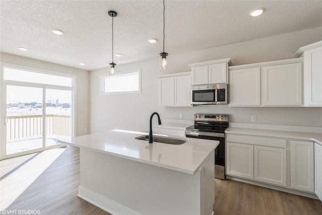 kitchen with appliances with stainless steel finishes, a sink, and white cabinets