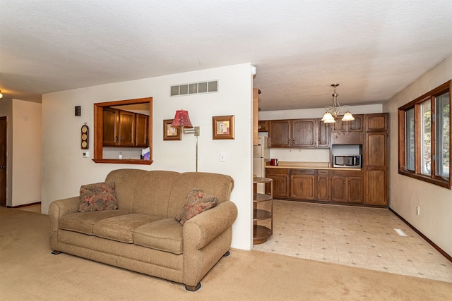 living room featuring light colored carpet, a textured ceiling, and a chandelier