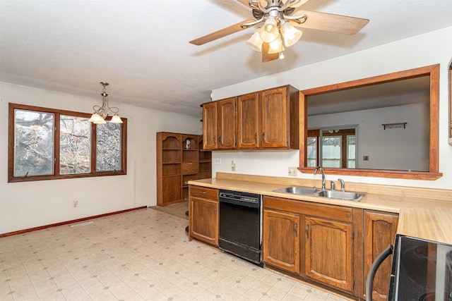 kitchen with a textured ceiling, dishwasher, range, decorative light fixtures, and sink