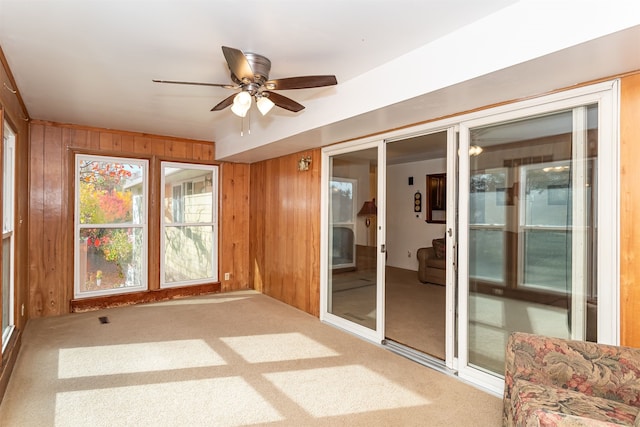 unfurnished sunroom featuring ceiling fan