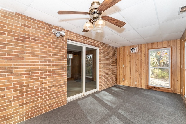 unfurnished sunroom featuring a drop ceiling and ceiling fan