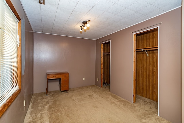 unfurnished bedroom featuring light carpet and a closet