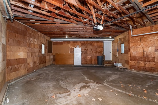 garage with a garage door opener and white fridge