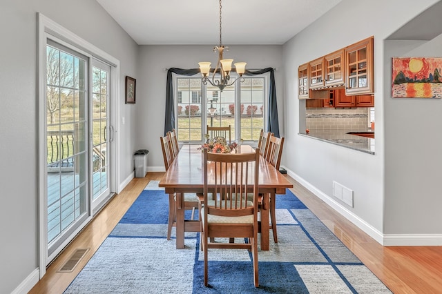 dining space with a notable chandelier and light wood-type flooring