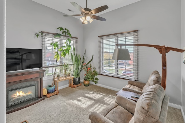 living room with a wealth of natural light, carpet, and ceiling fan