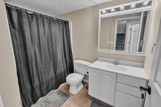 bathroom with a textured ceiling, walk in shower, toilet, vanity, and tile patterned floors