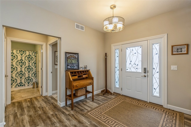 foyer entrance with a chandelier and hardwood / wood-style flooring