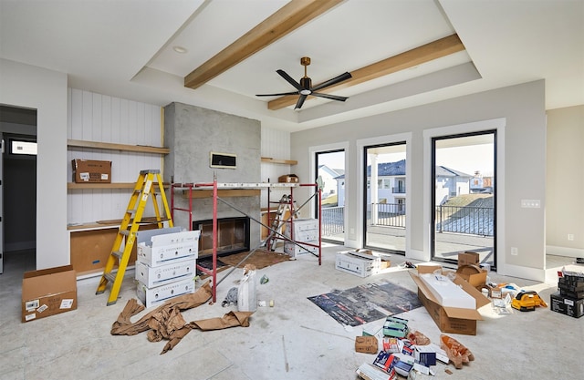 living room featuring a high end fireplace, a raised ceiling, and ceiling fan