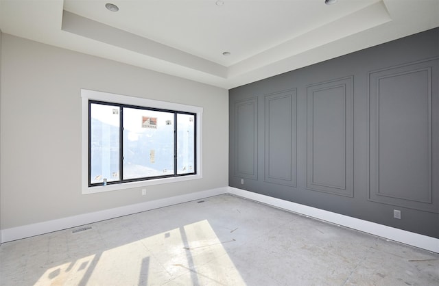 unfurnished room with a raised ceiling