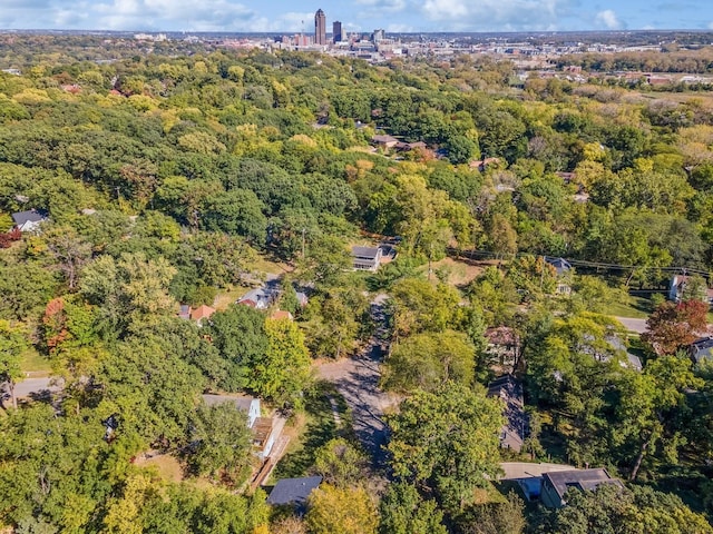 drone / aerial view featuring a wooded view and a city view