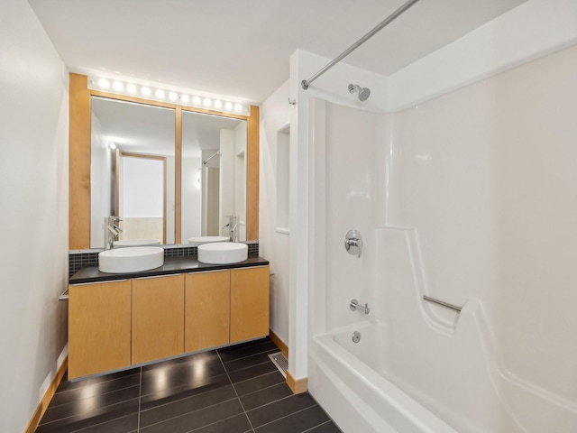 bathroom with tub / shower combination, a sink, baseboards, and double vanity