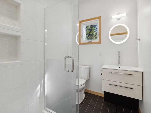 bathroom featuring toilet, vanity, baseboards, a shower stall, and tile patterned floors